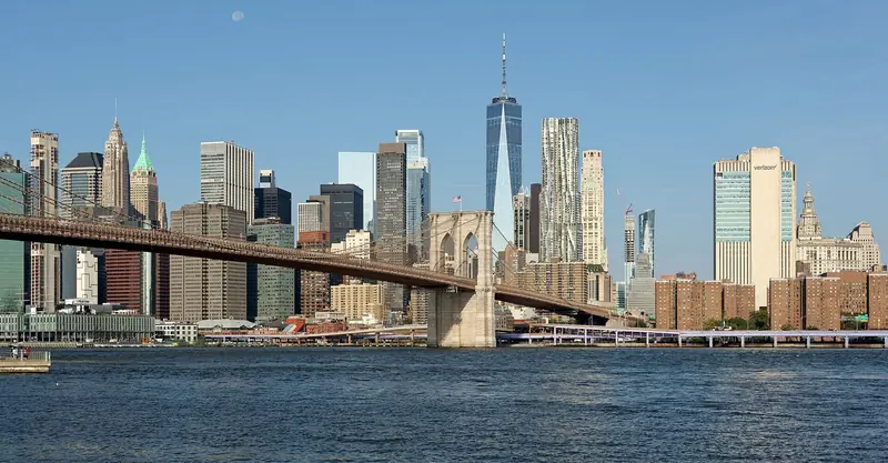 Ponte do Brooklyn atravessando o East River diante dos arranha-céus de Lower Manhattan, num dia de céu limpo